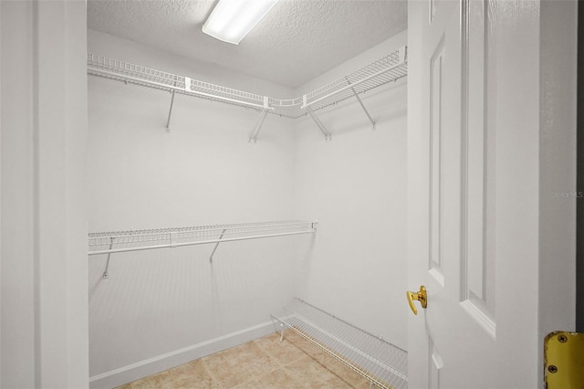 spacious closet featuring light tile patterned flooring