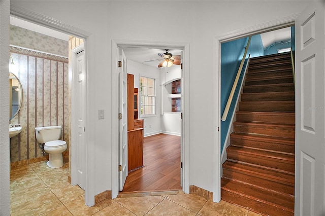 stairway featuring ceiling fan and wood-type flooring