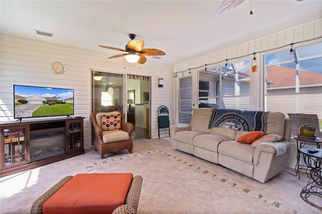 tiled living room with wood walls and ceiling fan