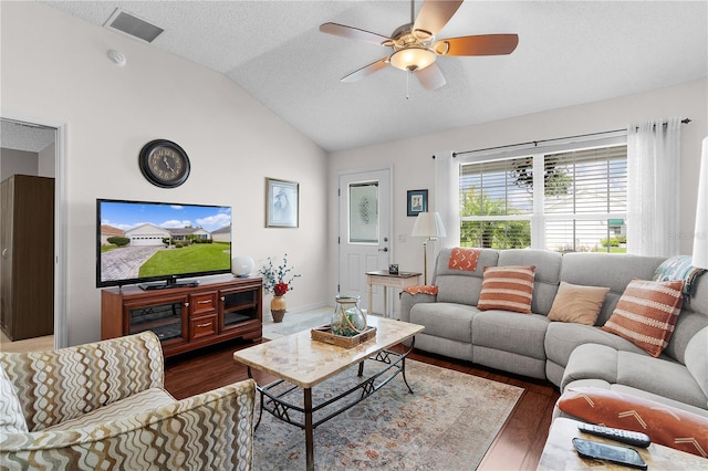 living room with dark wood-type flooring, lofted ceiling, ceiling fan, and a textured ceiling