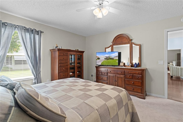 carpeted bedroom featuring a textured ceiling and ceiling fan