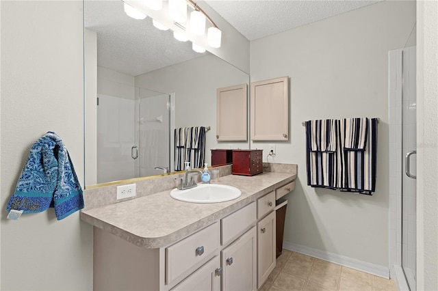 bathroom with vanity, a textured ceiling, an enclosed shower, and tile patterned flooring