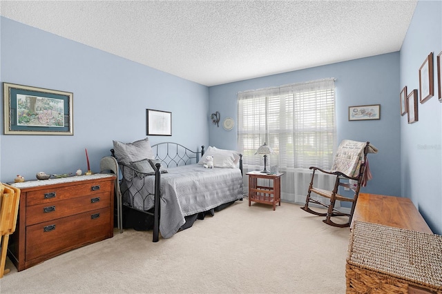 bedroom with a textured ceiling and light carpet