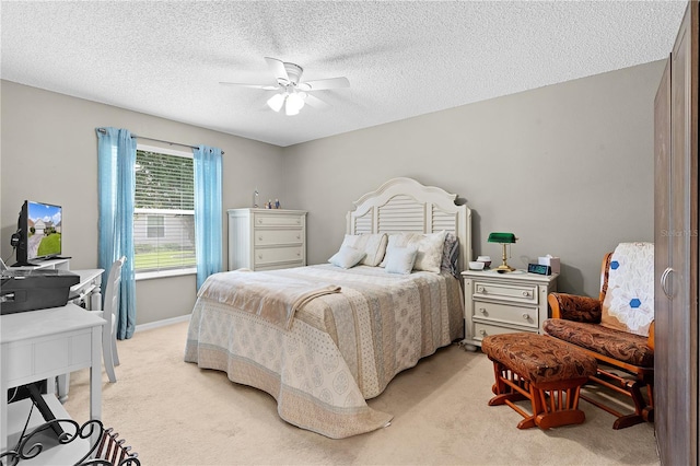 bedroom with a textured ceiling, light colored carpet, and ceiling fan