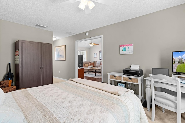 bedroom with light carpet, a textured ceiling, and ceiling fan