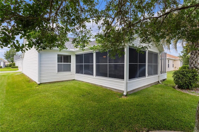 rear view of property with a sunroom and a yard