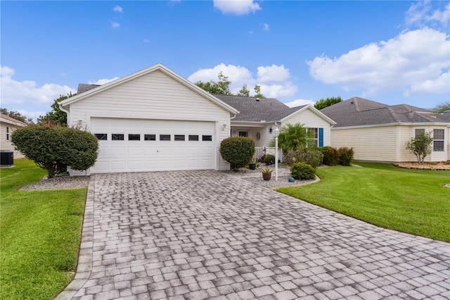 ranch-style home with a front yard, decorative driveway, central AC, and an attached garage