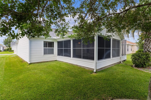 17913 SE 88th Cascade Ct, The Villages, FL 32162 - rear view of house with a lawn, a shingled roof, and a sunroom