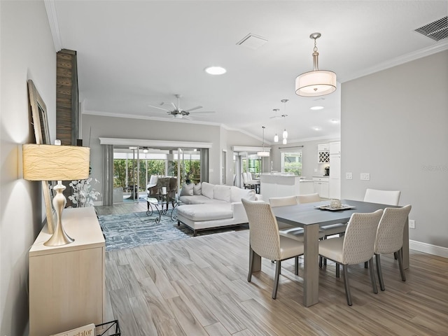 dining space with light hardwood / wood-style floors, ornamental molding, and ceiling fan