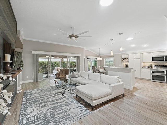 living room featuring lofted ceiling, ornamental molding, light hardwood / wood-style floors, and ceiling fan