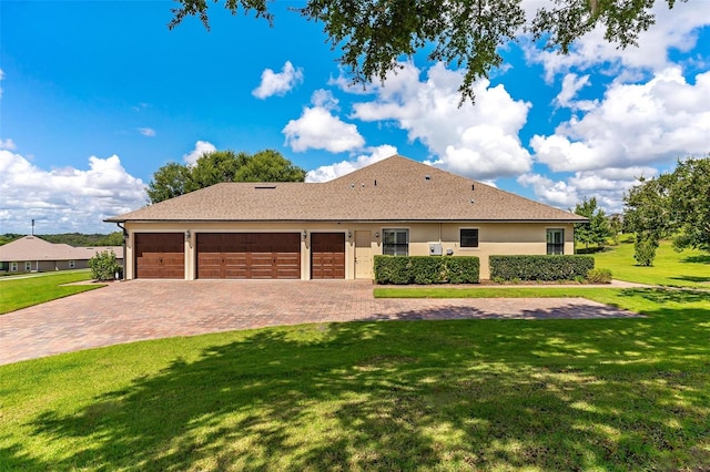 ranch-style home with a garage, decorative driveway, a front yard, and stucco siding