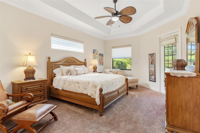 carpeted bedroom with a raised ceiling, crown molding, and baseboards