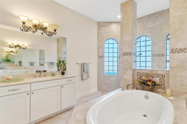 full bathroom with baseboards, a garden tub, vanity, a chandelier, and tile walls