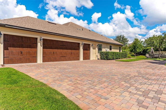 view of side of property with roof with shingles and stucco siding