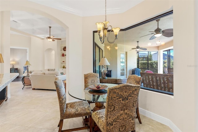 dining room with arched walkways, light tile patterned floors, a chandelier, baseboards, and built in features