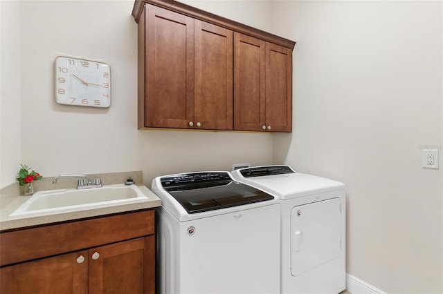 laundry area featuring washing machine and dryer, a sink, and cabinet space