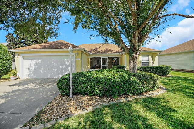 ranch-style home featuring a front yard and a garage