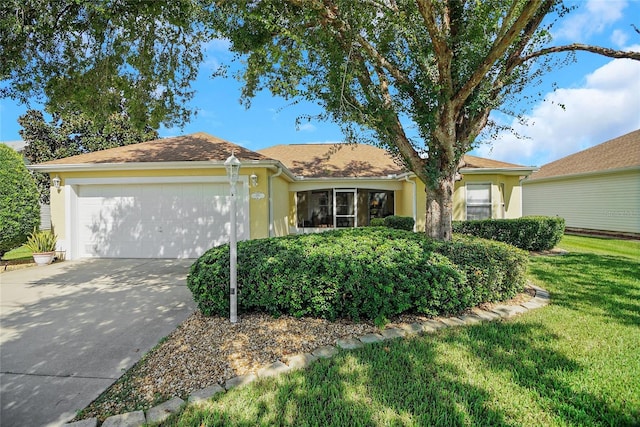 ranch-style house with a garage, concrete driveway, a front lawn, and stucco siding