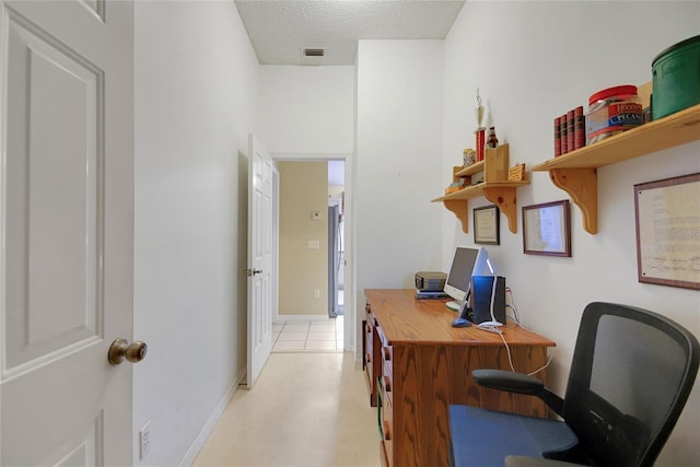 office with baseboards, visible vents, and a textured ceiling