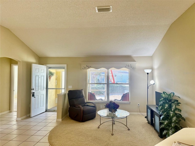 sitting room with visible vents, arched walkways, lofted ceiling, a textured ceiling, and light tile patterned flooring