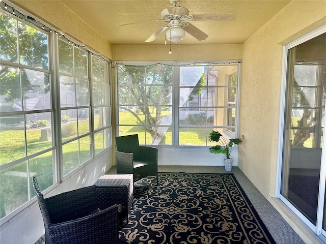 sunroom / solarium featuring a ceiling fan