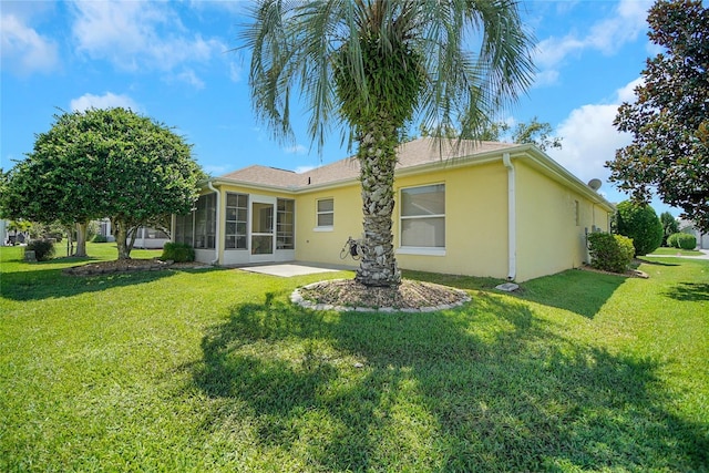 1213 El Esparza Ln, The Villages, FL 32159 - rear view of property with a sunroom, a yard, stucco siding, and a patio