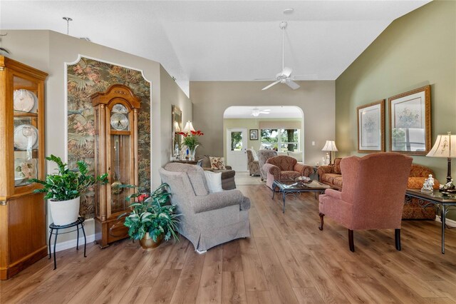 living room featuring lofted ceiling, ceiling fan, and light wood-type flooring