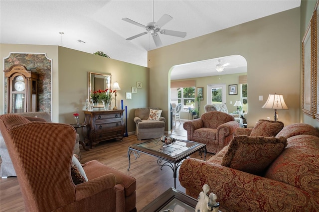 living room with light wood-type flooring, ceiling fan, and vaulted ceiling