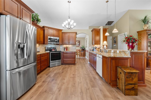 kitchen featuring light hardwood / wood-style flooring, decorative light fixtures, light stone countertops, stainless steel appliances, and kitchen peninsula