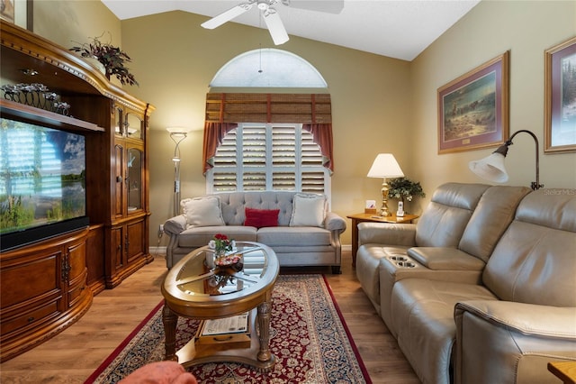 living room featuring lofted ceiling, ceiling fan, and light wood-type flooring