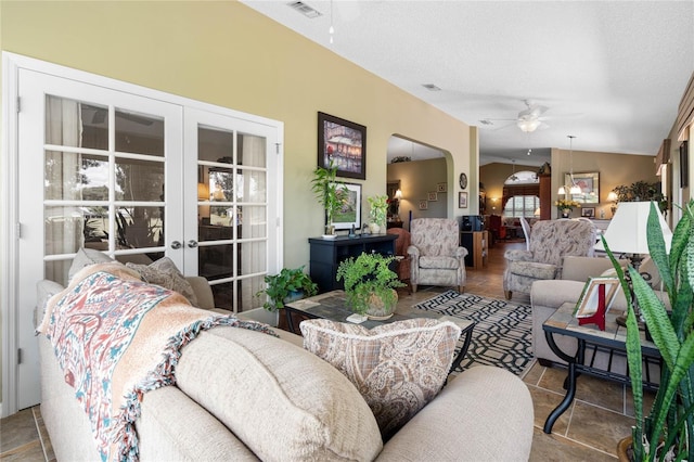 living room featuring ceiling fan, vaulted ceiling, a textured ceiling, and french doors