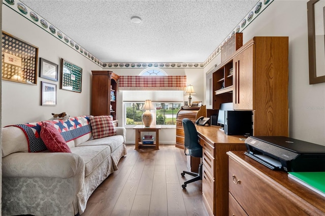 home office featuring hardwood / wood-style floors and a textured ceiling