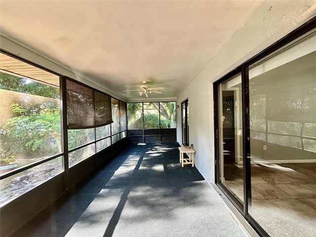 unfurnished sunroom with ceiling fan