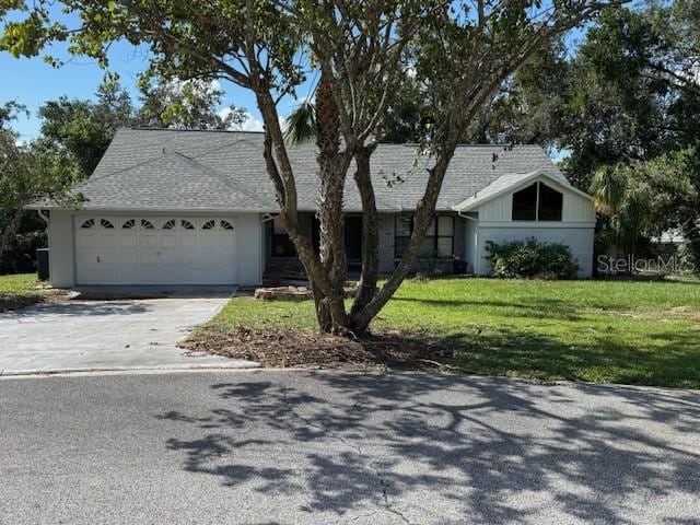 single story home featuring a garage and a front lawn