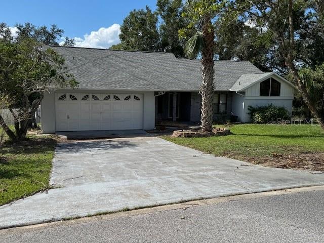 ranch-style home featuring a front lawn and a garage