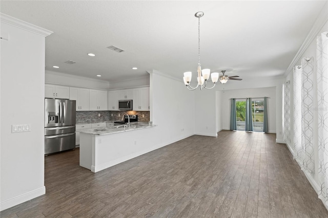 kitchen featuring white cabinets, decorative light fixtures, stainless steel appliances, backsplash, and kitchen peninsula