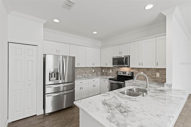 kitchen with appliances with stainless steel finishes, sink, and white cabinetry