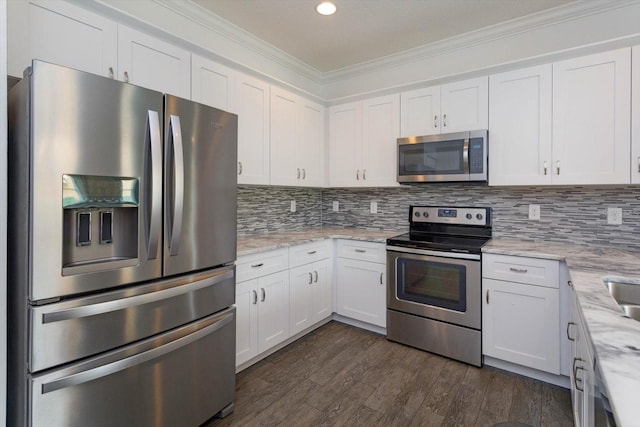 kitchen with decorative backsplash, light stone countertops, stainless steel appliances, and white cabinetry