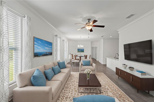 living room featuring crown molding, ceiling fan with notable chandelier, and hardwood / wood-style floors