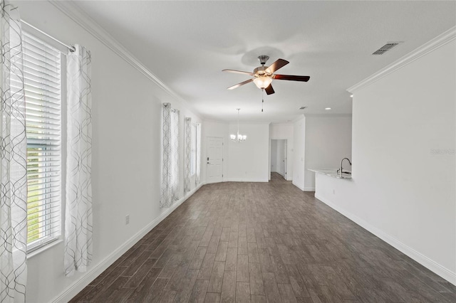 unfurnished living room featuring ceiling fan with notable chandelier, dark hardwood / wood-style flooring, and crown molding