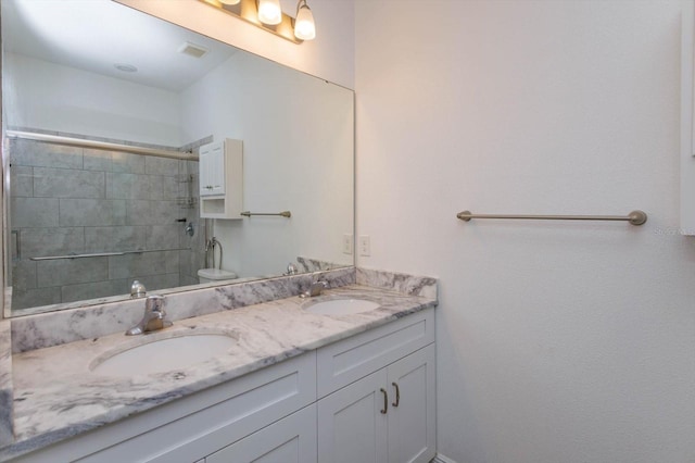 bathroom featuring a shower with shower door, toilet, and vanity