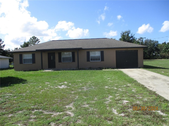 single story home featuring a garage and a front lawn