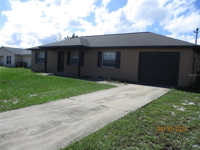 single story home with a garage and a front lawn