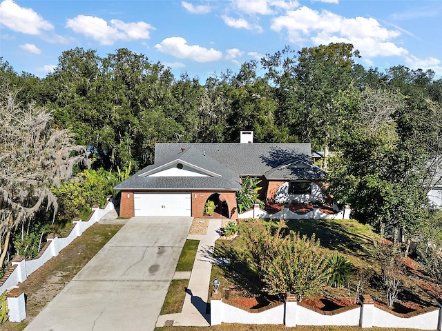 view of front of home featuring concrete driveway, brick siding, fence, and an attached garage