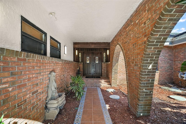 view of exterior entry with brick siding