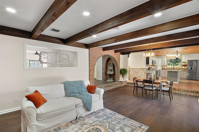 living room with dark hardwood / wood-style flooring and beamed ceiling