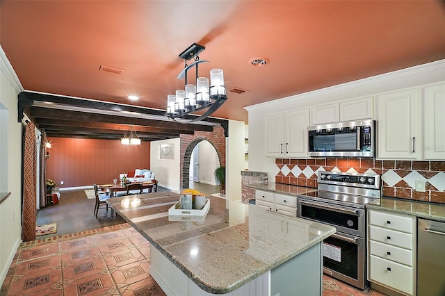 kitchen featuring appliances with stainless steel finishes, a center island, and decorative backsplash