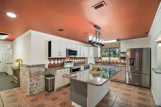 kitchen with sink, decorative light fixtures, appliances with stainless steel finishes, decorative backsplash, and white cabinets