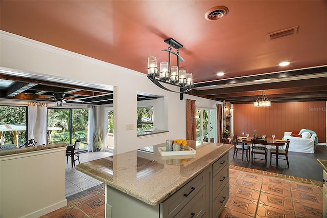 kitchen with dark tile patterned floors, ceiling fan with notable chandelier, beam ceiling, and decorative light fixtures