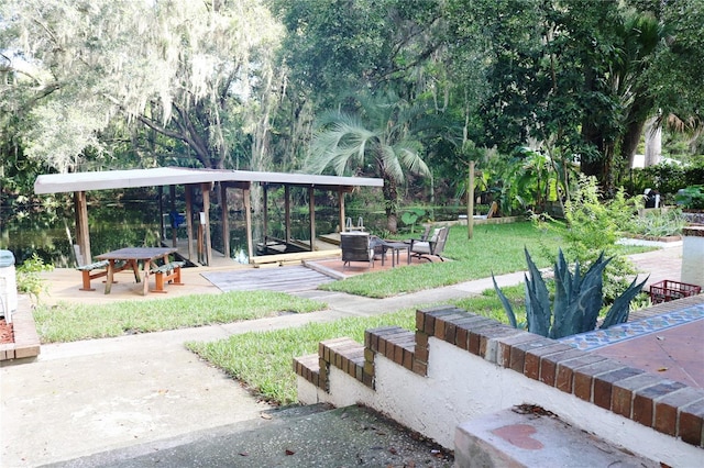 surrounding community featuring a patio area, a fire pit, and a lawn